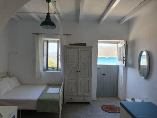 Habitación blanca con cama y ventana en Merope seaside house, en Platis Yialos Sifnos