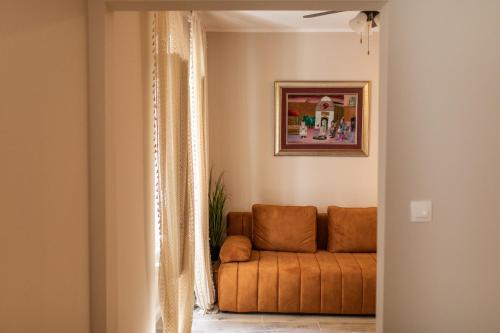 um sofá laranja numa sala de estar com um quadro em Stanley Helenski - apartment in old town em Šibenik