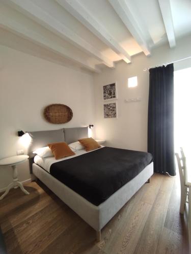 a bedroom with a large bed and a table at La Maison in Trani