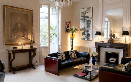 a living room with a couch and a fireplace at Hôtel Bristol Pau in Pau