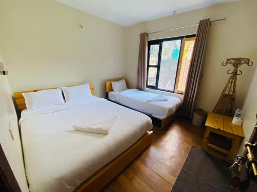 a bedroom with two beds and a window at Hotel Aagaman - Best Family Hotel in Bandipur in Bandīpur