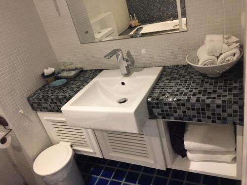 a bathroom with a sink and a toilet at At Pingnakorn Nimman Hotel in Chiang Mai