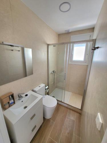 a bathroom with a toilet and a shower and a sink at Apartamento a estrenar en Planta Primera C con piscina in Barbate