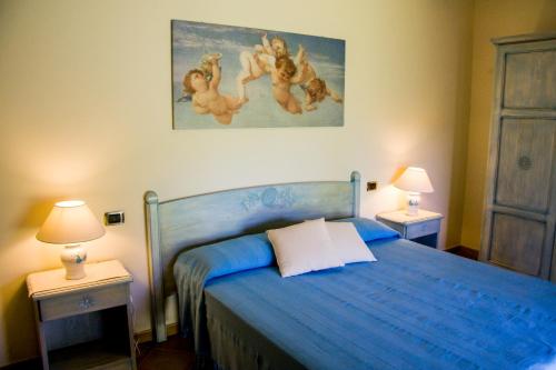 a bedroom with a blue bed with two night stands at Villa Luna Smeralda ad Alghero villa con piscina ad uso esclusivo per 8 persone in Alghero