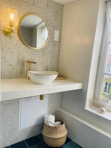 une salle de bain avec un lavabo et un miroir dans l'établissement Appartement Chèvremont Metz, à Metz