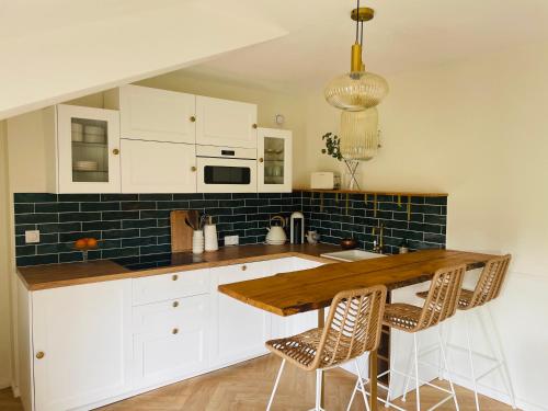 une cuisine avec des placards blancs et un comptoir en bois dans l'établissement Appartement Chèvremont Metz, à Metz