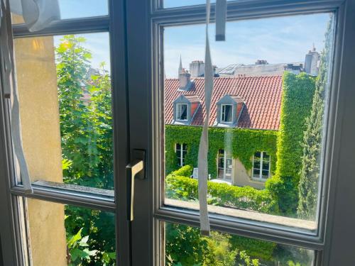 une fenêtre ouverte avec vue sur une maison dans l'établissement Appartement Chèvremont Metz, à Metz