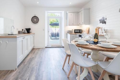 a kitchen and dining room with a table and chairs at Canol Y Bryn - 3 Bedroom Holiday Home - Tenby in Tenby