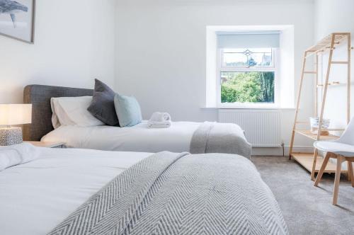 duas camas num quarto com uma escada e uma janela em Canol Y Bryn - 3 Bedroom Holiday Home - Tenby em Tenby