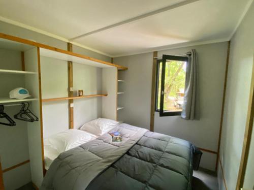 a small bedroom with a bed and a window at Camping Paradis Le Céou in Saint-Cybranet