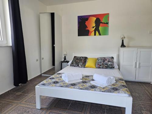 1 dormitorio con 1 cama blanca y 2 almohadas en Apartments ANTONIA - S. Novalja, en Stara Novalja