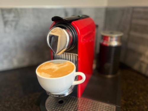 a coffee machine with a cup of coffee on a table at Live Large in the Village in Havelock North