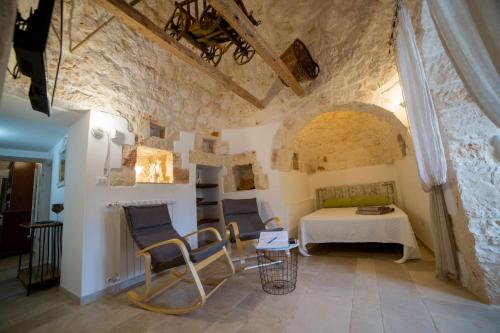 オストゥーニにあるTrullo Ostuni Terre di Santaのベッドルーム1室(ベッド1台、テーブル、椅子付)