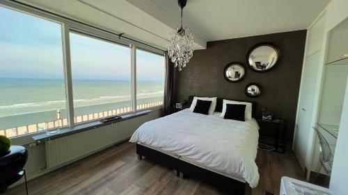 1 dormitorio con 1 cama y vistas al océano en Ocean BreezeApartment: WakeUp 2 Sound of the Waves en Zandvoort