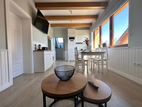 a kitchen and living room with a table and chairs at AURA Centrum Wypoczynkowo-Rekreacyjne in Sejny