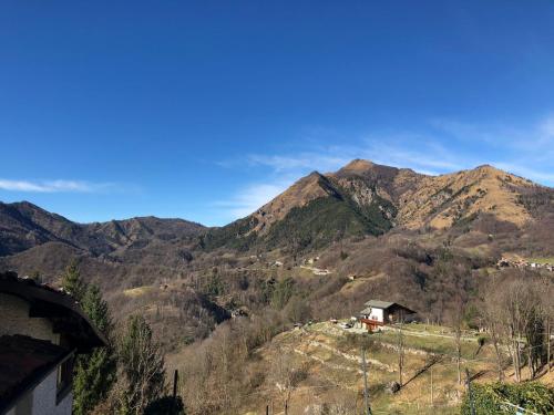 vistas a una montaña con una casa en una colina en Camera Delux matrimoniale, en Serina