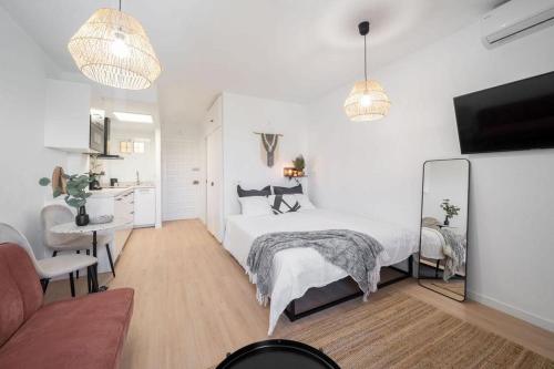ein weißes Schlafzimmer mit einem Bett und einem Schreibtisch in der Unterkunft Benalmadena Jupiter Sunsea View Apartments in Benalmádena