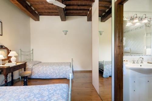 1 dormitorio con 2 camas, lavabo y espejo en Villa Castelluccio, 