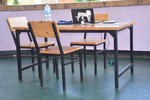 a table with four chairs and a laptop on it at Kili View Lodge in Moshi