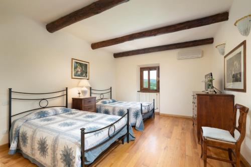 1 dormitorio con 2 camas y suelo de madera en Villa Castelluccio, 