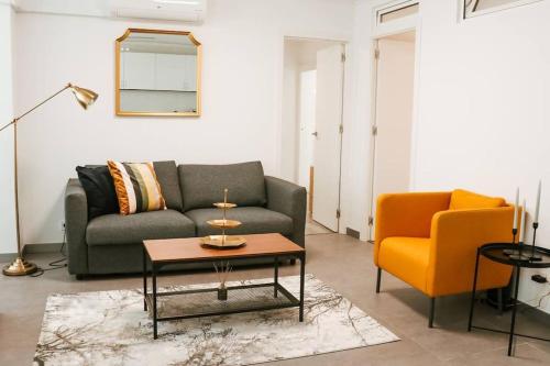 a living room with a couch and a chair at Golden Place-Costa da Caparica in Costa da Caparica