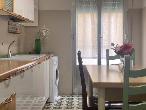 cocina con mesa y lavadora en Come in and relax, en Pachino