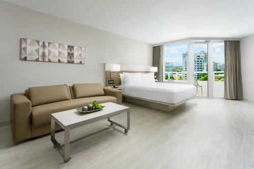 a hotel room with a bed and a couch and a table at AC Hotel by Marriott San Juan Condado in San Juan