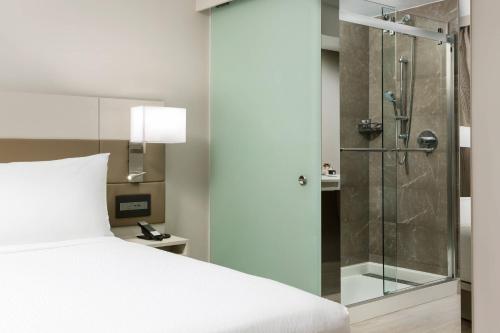 a bedroom with a bed and a glass shower at AC Hotel by Marriott San Juan Condado in San Juan