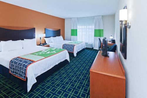 a hotel room with two beds and a flat screen tv at Fairfield Inn & Suites Tulsa South Medical District in Tulsa