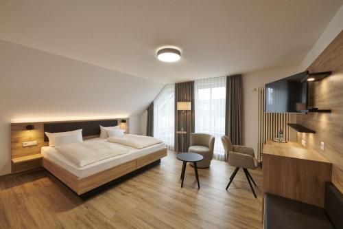 a hotel room with a bed and a table at Kreuz-Post Hotel-Restaurant-SPA in Vogtsburg
