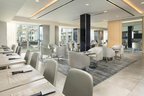 a restaurant with white chairs and tables and windows at AC Hotel by Marriott San Juan Condado in San Juan