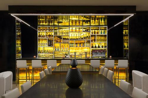 a dining room with a long table and a bar at AC Hotel by Marriott San Juan Condado in San Juan