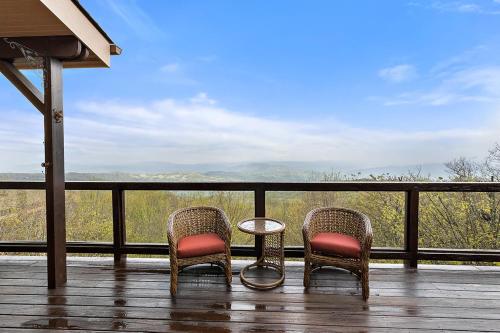 two chairs and a table on a porch with a view at Bella Vista in Beech Mountain
