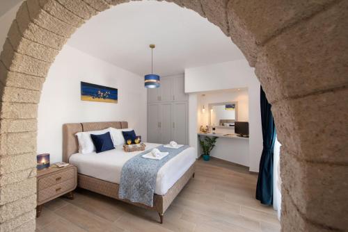 アルハンゲロスにあるAntonia's Apartmentsのアーチのある部屋のベッドルーム1室(ベッド1台付)