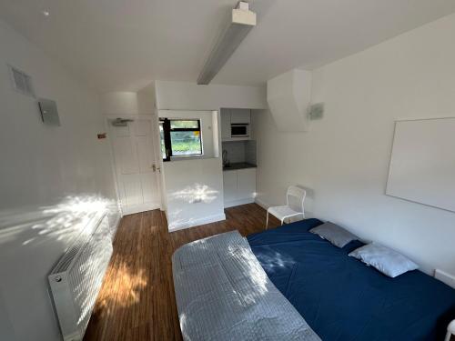 Un dormitorio con una cama azul y una ventana en Santry Studio, en Dublín