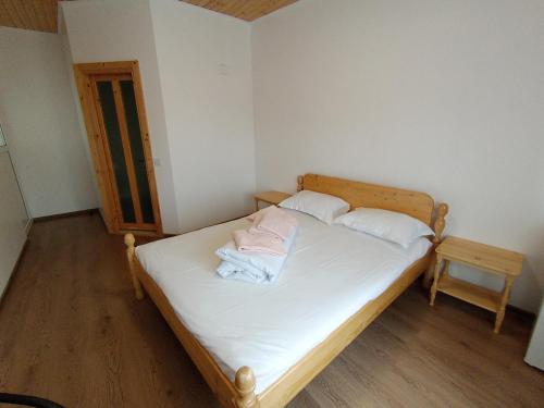 a small bedroom with a bed with white sheets and pillows at La Mariana in Vama Veche