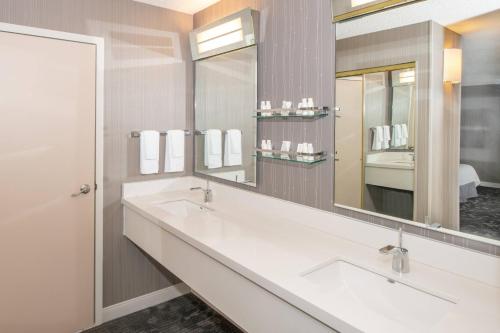 a bathroom with two sinks and a large mirror at Courtyard by Marriott Oakland Airport in Oakland