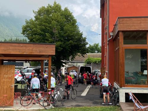 a large group of people walking their bikes down a street at h&ocirc;tel oberland in Le Bourg-dʼOisans
