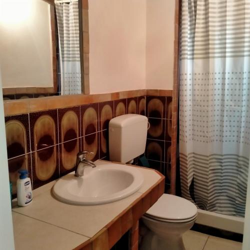 uma casa de banho com um lavatório, um WC e um espelho. em MANSARDA MARE BLUE em Sciacca