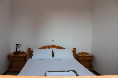 a bedroom with a bed and two nightstanduments at Nikos Seaside Apartments in Litherés