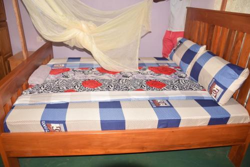 a bed with a blue and white plaid at Kili View Lodge in Moshi