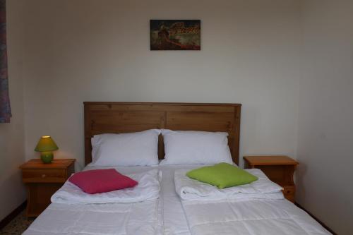 a bed with two pillows on it in a bedroom at Nikos Seaside Apartments in Litherés
