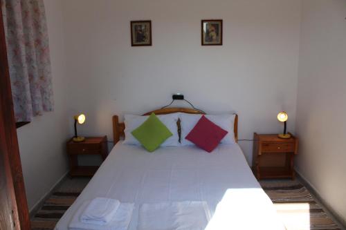 a bedroom with a bed with three pillows on it at Nikos Seaside Apartments in (( Litherés ))