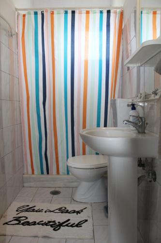 a bathroom with a sink and a shower curtain at Nikos Seaside Apartments in Litherés