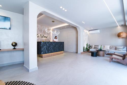 a lobby of a hotel with a woman standing at a counter at Le Palme in Malia