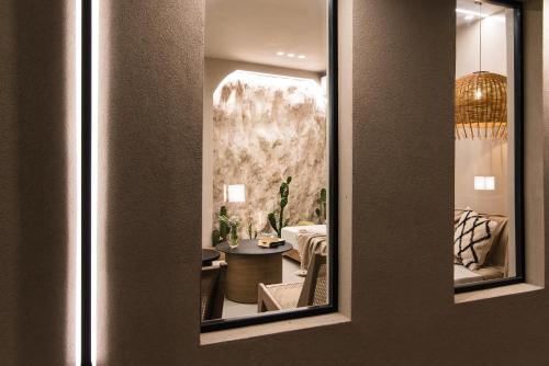 a mirror reflecting a living room with a table at Le Palme in Malia