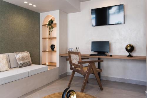 a living room with a couch and a desk with a computer at Le Palme in Malia