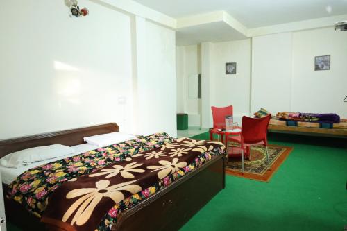a bedroom with a bed and a table and a chair at Paradise Guest House Dalhousie- Near Panchpula Water Fall in Dalhousie