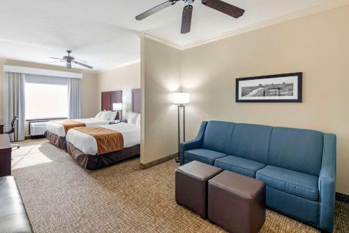 um quarto de hotel com um sofá e uma cama em Comfort Inn & Suites Fort Worth - Fossil Creek em Fort Worth
