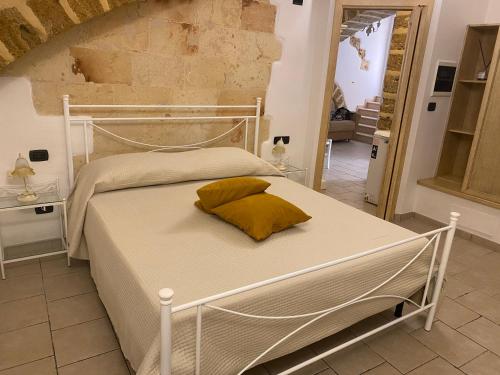 ein Schlafzimmer mit einem weißen Bett und einem gelben Kissen in der Unterkunft CASA VACANZE DANTE in Mesagne